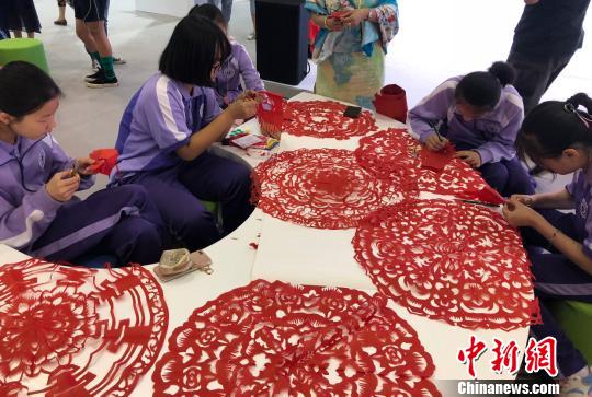 6月9日,“流动的文化——大运河文化带非遗大展暨第四届京津冀非遗联展”在京举办。图为来自北京的中学生们现场展示剪纸技艺。(完) 尹力 摄 6月9日,“流动的文化——大运河文化带非遗大展暨第四届京津冀非遗联展”在京举办。图为来自北京的中学生们现场展示剪纸技艺。(完) 尹力 摄